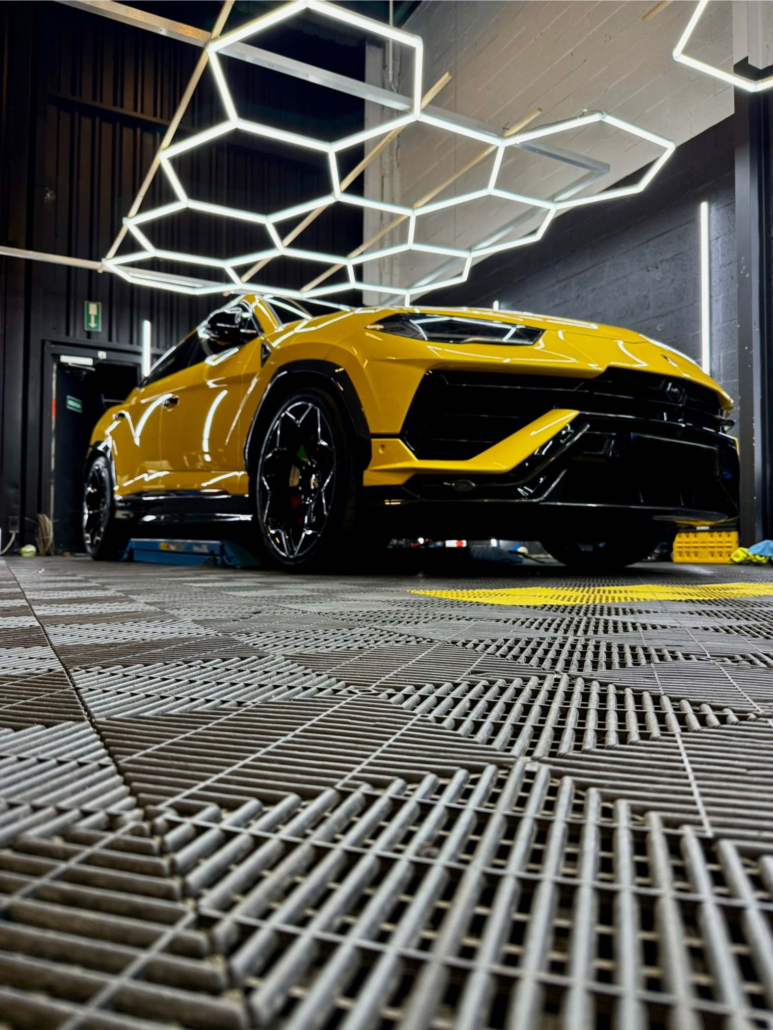 Gele Lamborghini Huracan in Dtailercrew studio met hexagonale LED-verlichting